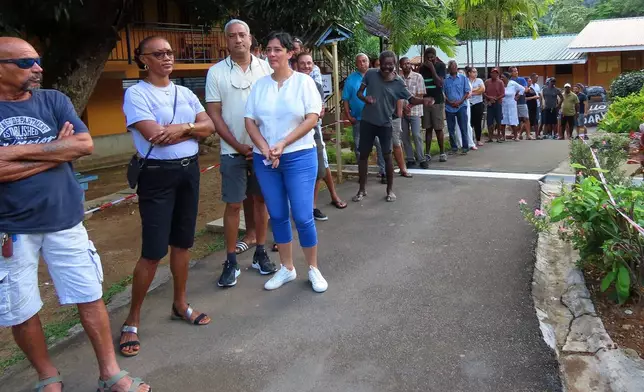 People line up to cast their votes at Beau Vallon Secondary School in Beau Vallon, Seychelles, on Saturday, Sep. 27, 2025. (AP Photo/Emilie Chetty)