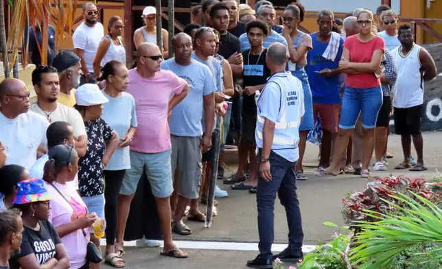 People line up to cast their votes at Beau Vallon Secondary School in Beau Vallon, Seychelles, on Saturday, Sep. 27, 2025. (AP Photo/Emilie Chetty)