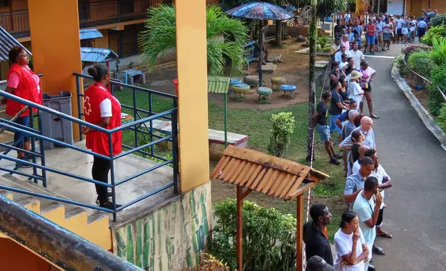 People line up to cast their votes at Beau Vallon Secondary School in Beau Vallon, Seychelles, on Saturday, Sep. 27, 2025. (AP Photo/Emilie Chetty)