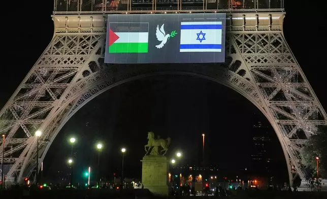 A large screen displays Palestinian and Israeli flags and a dove on the Eiffel Tower, Sunday, Sept. 21, 2025, in Paris, as France prepares to formally recognize a Palestinian state at the United Nations General Assembly. (AP Photo/Christophe Ena)