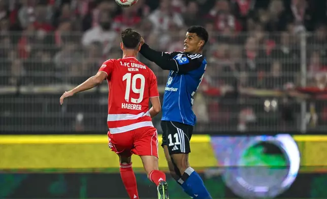 Berlin's Janik Haberer, left, and Hamburger's Ransford Königsdörffer in action during the Bundesliga soccer match between FC Union Berlin and Hamburger SV in Berlin, Sunday Sept. 28, 2025. (Soeren Stache/dpa via AP)
