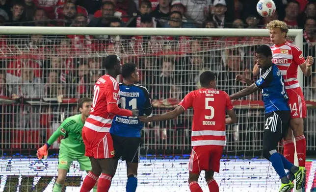 Berlin's Leopold Querfeld, right, and Hamburger's Warmed Omari go for a header during the Bundesliga soccer match between FC Union Berlin and Hamburger SV in Berlin, Sunday Sept. 28, 2025. (Soeren Stache/dpa via AP)
