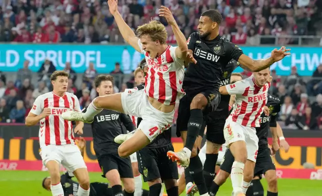 Cologne's Timo Huebers challenges with Stuttgart's Josha Vagnoman during the German Bundesliga soccer match between 1.FC Köln and VfB Stuttgart in Cologne, Germany, Sunday, Sept. 28, 2025. (AP Photo/Martin Meissner)