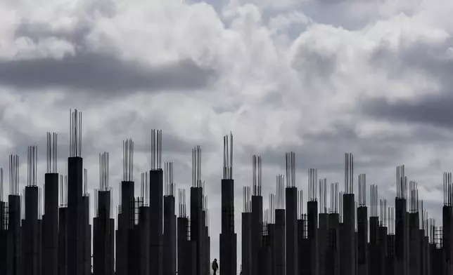 A worker walks through a building under construction in Georgetown, Guyana, Tuesday, Sept. 2, 2025. (AP Photo/Matias Delacroix)