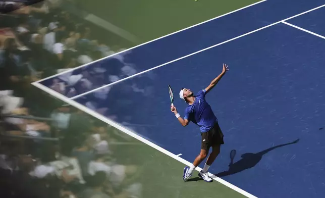 Leandro Riedi, of Switzerland, serves against Alex de Minaur, of Australia, during the fourth round of the US Open tennis championships, Monday, Sept. 1, 2025, in New York. (AP Photo/Heather Khalifa)