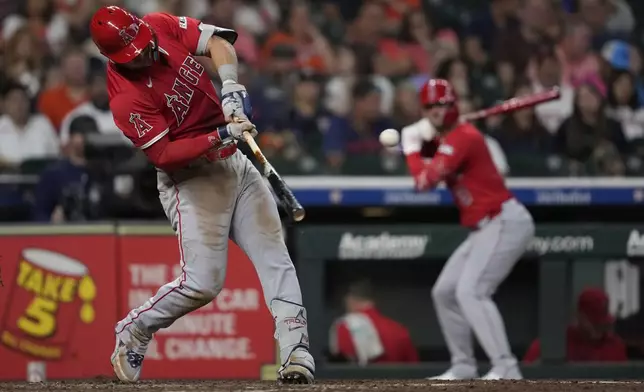 Los Angeles Angels designated hitter Mike Trout, left, doubles during the eighth inning of a baseball game against the Houston Astros in Houston, Sunday, Aug. 31, 2025. (AP Photo/Ashley Landis)