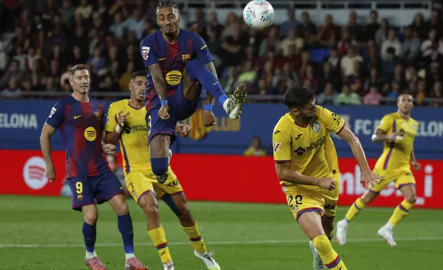 Barcelona's Raphinha jumps for the ball during a Spanish La Liga soccer match between FC Barcelona and Getafe at the Johan Cruyff stadium in Barcelona, Spain, Sunday, Sept. 21, 2025. (AP Photo/Joan Monfort)