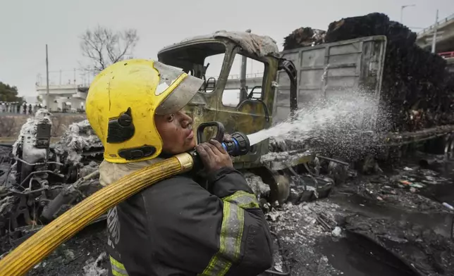 A firefighter sprays a hose after a gas tanker exploded in Mexico City, Wednesday, Sept. 10, 2025. (AP Photo/Fernando Llano)