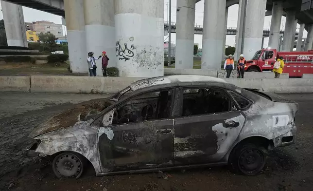 A burned car sits below an underpass following a gas tanker explosion in Mexico City, Wednesday, Sept. 10, 2025. (AP Photo/Fernando Llano)
