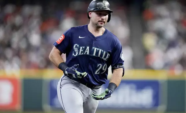 Seattle Mariners' Cal Raleigh gestures to the Mariners' dugout as he rounds the bases after hitting a solo home run, his 57th of the season, against the Houston Astros during the third inning of a baseball game Saturday, Sept. 20, 2025, in Houston. (AP Photo/Eric Christian Smith)
