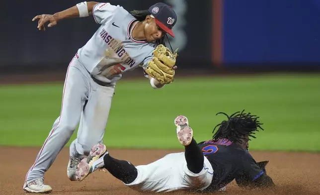 New York Mets' Luisangel Acuña slides past Washington Nationals' CJ Abrams, left, to steal second base during the seventh inning of a baseball game Friday, Sept. 19, 2025, in New York. (AP Photo/Frank Franklin II)