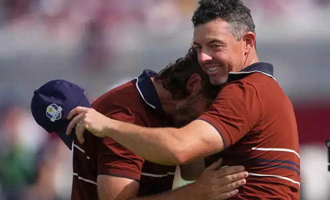Europe's Rory McIlroy and Tommy Fleetwood hug after they won their match at Bethpage Black golf course during the Ryder Cup golf tournament, Saturday, Sept. 27, 2025, in Farmingdale, N.Y. (AP Photo/Lindsey Wasson)