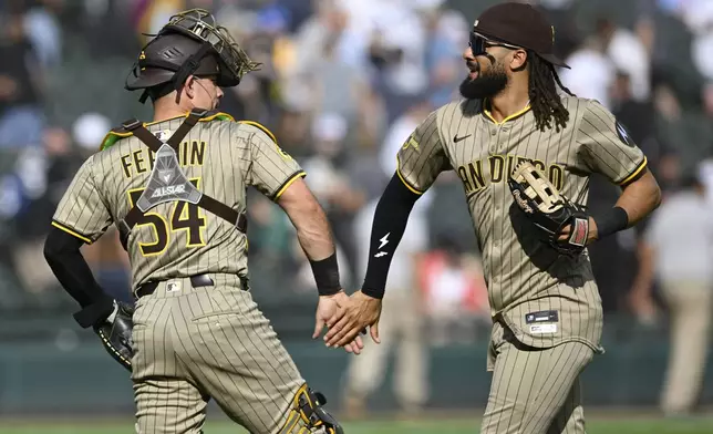 San Diego Padres' Fernando Tatis Jr., right, celebrates with catcher Freddy Fermin (54) after defeating the Chicago White Sox in a baseball game Sunday, Sept. 21, 2025, in Chicago. (AP Photo/Paul Beaty)