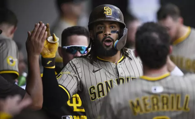 San Diego Padres' Fernando Tatis Jr. celebrates with teammates in the dugout after hitting a solo home run during the third inning of a baseball game against the Chicago White Sox, Sunday, Sept. 21, 2025, in Chicago. (AP Photo/Paul Beaty)