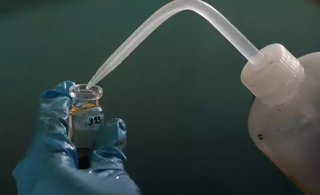 Expedition 501 researcher Jack Brickell prepares a sample vial for analysis aboard the Liftboat Robert platform in the North Atlantic, Sunday, July 20, 2025. (AP Photo/Carolyn Kaster)