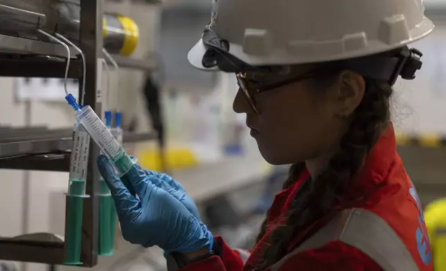 Expedition 501 researcher Alizé Longeau collects water samples from cores aboard the Liftboat Robert platform, in the North Atlantic, in the early morning hours, Sunday, July 20, 2025. (AP Photo/Carolyn Kaster)