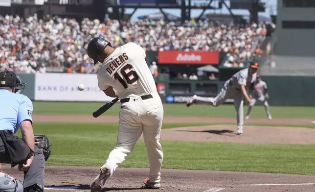 San Francisco Giants' Rafael Devers (16) hits an RBI single off of Baltimore Orioles pitcher Tomoyuki Sugano, middle right, during the third inning of a baseball game in San Francisco, Sunday, Aug. 31, 2025. (AP Photo/Jeff Chiu)