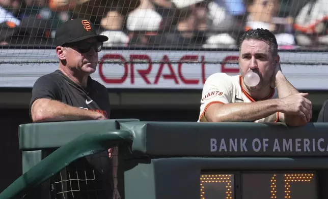 San Francisco Giants pitcher Justin Verlander, right, blows a bubble while watching from the dugout next to manager Bob Melvin during the fifth inning of a baseball game against the Baltimore Orioles in San Francisco, Sunday, Aug. 31, 2025. (AP Photo/Jeff Chiu)