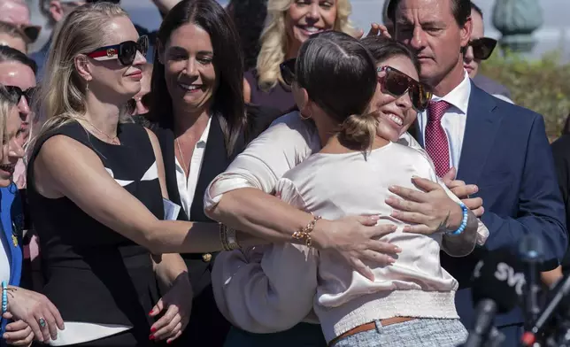 Anouska de Georgiou, left, Haley Robson, center, hug Marina Lacerda during a news conference at the U.S. Capitol, Wednesday, Sept. 3, 2025, in Washington. (AP Photo/Jose Luis Magana)