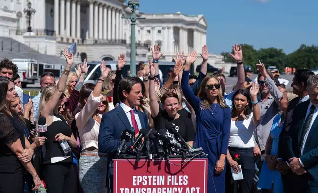 Attendees raise their hands to press congress to release the Jeffrey Epstein files during a news conference at the U.S. Capitol, Wednesday, Sept. 3, 2025, in Washington. (AP Photo/Jose Luis Magana)