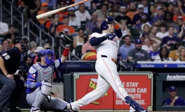 Houston Astros's Victor Caratini, right, loses his bat on his swing in front of Texas Rangers catcher Kyle Higashioka, center, and umpire Cory Blaser, left, during the seventh inning of a baseball game Tuesday, Sept. 16, 2025, in Houston. (AP Photo/Michael Wyke)