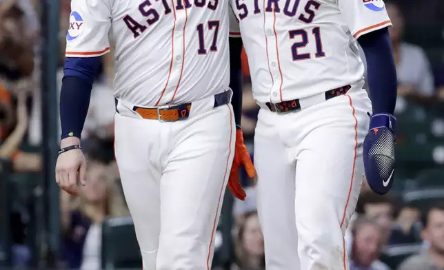 Houston Astros' Victor Caratini (17) and Yainer Diaz (21) celebrate after the both scored on the RBI single by Jesus Sanchez against the Texas Rangers during the fourth inning of a baseball game Tuesday, Sept. 16, 2025, in Houston. (AP Photo/Michael Wyke)