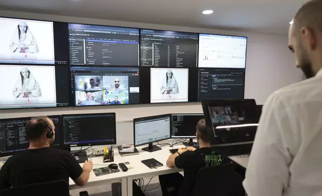 Albanian experts work at the National Agency for Information Society as an artificial intelligence "minister" Diella, whose name means "Sun" in Albanian, is seen on the screens in Tirana, Albania, Friday, Sept. 12, 2025. (AP Photo/Vlasov Sulaj)