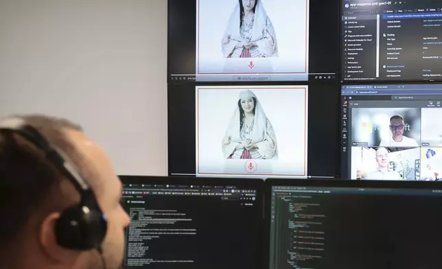 An Albanian expert works at the National Agency for Information Society as an artificial intelligence "minister" Diella, whose name means "Sun" in Albanian, is seen on the screens in Tirana, Albania, Friday, Sept. 12, 2025. (AP Photo/Vlasov Sulaj)