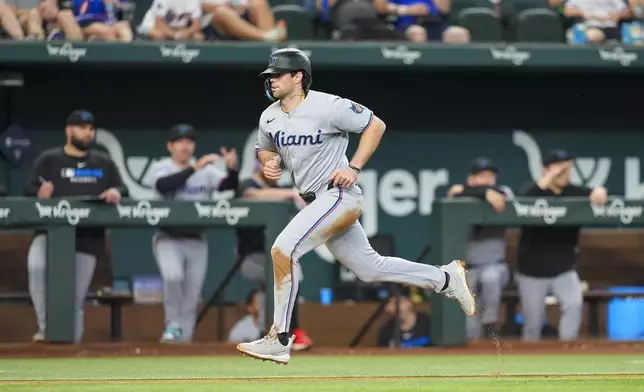 Miami Marlins' Graham Pauley scores a run off a sacrifice fly ball by teammate Brian Navarreto during the seventh inning of a baseball game against the Texas Rangers Sunday, Sept. 21, 2025, in Arlington, Texas. (AP Photo/Ronaldo Bolaños)