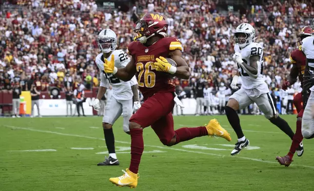 Washington Commanders running back Jeremy McNichols (26) breaks free from Las Vegas Raiders defense and runs in a touchdown during the first half of NFL football game Sunday, Sept. 21, 2025, in Landover, Md. (AP Photo/Nick Wass)