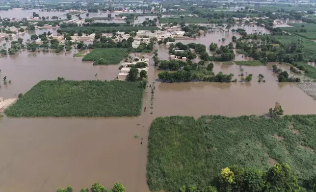 Villagers wade through a flooded area, in Tiba Gheal village, in Jhang district, Pakistan, Tuesday, Sept. 2, 2025. (AP Photo/Jahan Zeb)