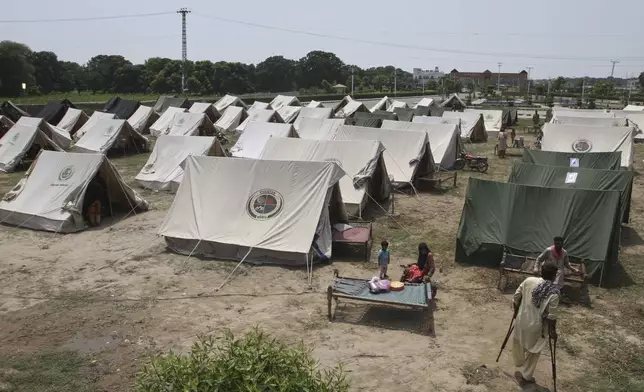 People, who fled from their homes due to flood, take shelter at a relief camp on the outskirts of Multan, Pakistan, Tuesday, Sept. 2, 2025. (AP Photo/Asim Tanveer)
