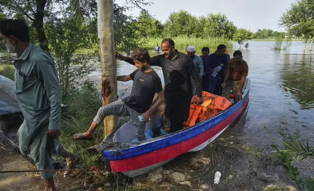 Villagers are evacuated by rescue workers from a flooded area in Muza Islam Wala, in Jhang district, Pakistan, Tuesday, Sept. 2, 2025. (AP Photo/K.M. Chaudary)