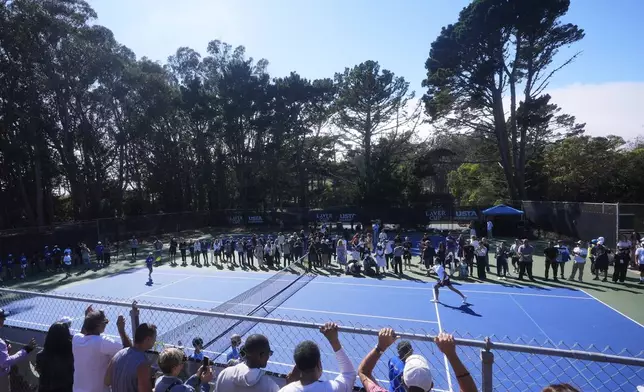 Co-creator of the Laver Cup Roger Federer, middle right, hits tennis balls to local youth tennis players during a court unveiling at John McLaren Park Tennis Courts before the Laver Cup tennis matches in San Francisco, Tuesday, Sept. 16, 2025. (AP Photo/Jeff Chiu)