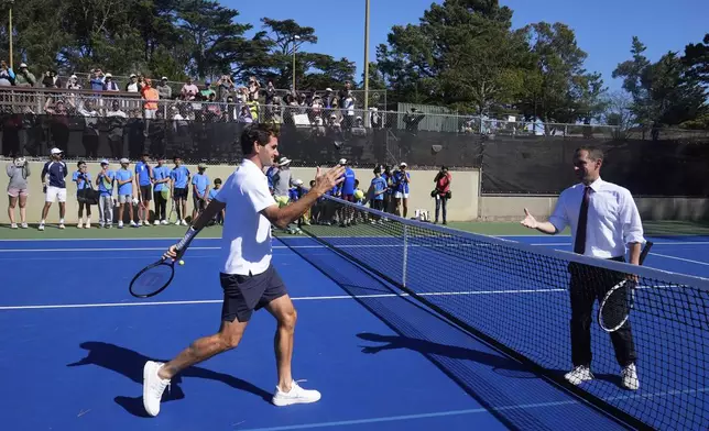 Co-creator of the Laver Cup Roger Federer, left, greets San Francisco Mayor Daniel Lurie after hitting tennis balls during a court unveiling at John McLaren Park Tennis Courts before the Laver Cup tennis matches in San Francisco, Tuesday, Sept. 16, 2025. (AP Photo/Jeff Chiu)
