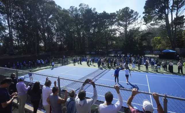 Team Europe captain Yannick Noah, midde left, and co-creator of the Laver Cup Roger Federer react while hitting tennis balls to local youth tennis players during a court unveiling at John McLaren Park Tennis Courts before the Laver Cup tennis matches in San Francisco, Tuesday, Sept. 16, 2025. (AP Photo/Jeff Chiu)