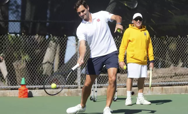 Co-creator of the Laver Cup Roger Federer hits tennis balls to local youth tennis players during a court unveiling at John McLaren Park Tennis Courts before the Laver Cup tennis matches in San Francisco, Tuesday, Sept. 16, 2025. (AP Photo/Jeff Chiu)