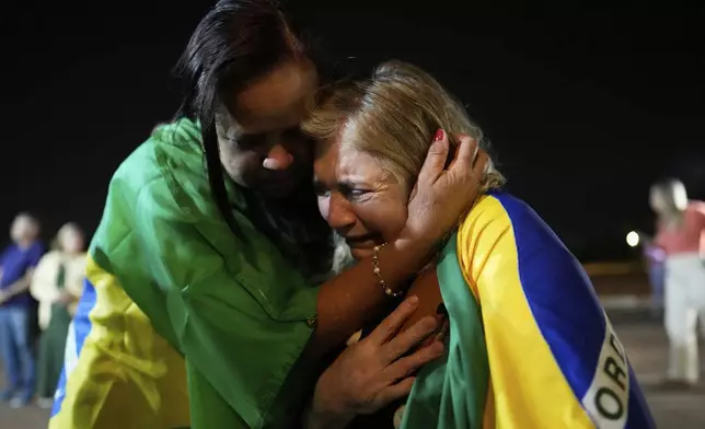Supporters of former President Jair Bolsonaro cry during a vigil in his support near his home where he is under house arrest in Brasilia, Brazil, Thursday, Sept. 11, 2025. (AP Photo/Eraldo Peres)