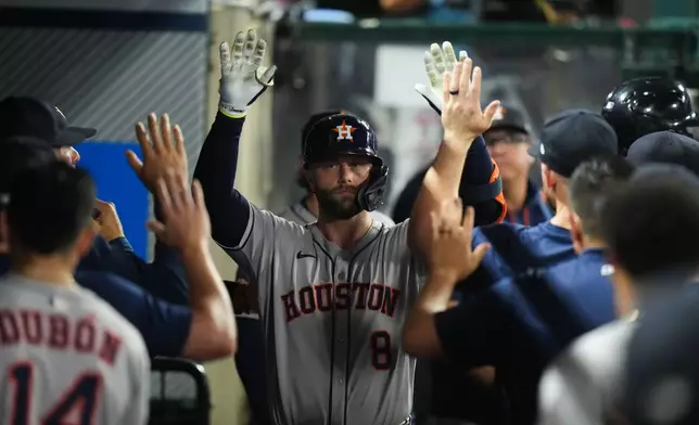 Houston Astros' Christian Walker (8) celebrates his home run with teammates during the fourth inning of a baseball game against the Los Angeles Angels Saturday, Sept. 27, 2025, in Anaheim, Calif. (AP Photo/Jae C. Hong)