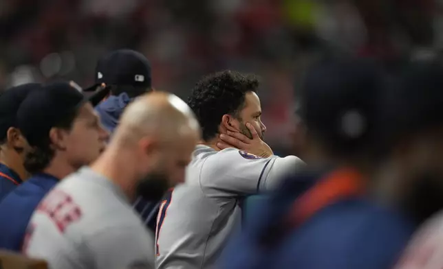 Houston Astros' Jose Altuve, center, and his teammates watch from the dugout during the fifth inning of a baseball game against the Los Angeles Angels Saturday, Sept. 27, 2025, in Anaheim, Calif. (AP Photo/Jae C. Hong)