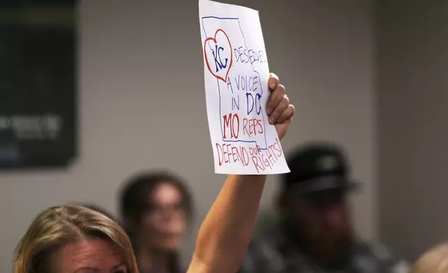 A person lifts a sign as Missouri lawmakers hold a committee hearing to consider redrawing the state's U.S. House districts Thursday, Sept. 4, 2025, in Jefferson City, Mo. (AP Photo/Jeff Roberson)