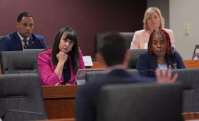Members of the Missouri House Democratic caucus, Rep. Mark Sharp, left, Rep. Ashley Aune, second from left, Rep. Kathy Steinhoff, top right, and Rep. Kem Smith, bottom right, listen as Rep. Dirk Deaton, R-Seneca, center, and sponsor of a bill that would redraw the state's U.S. House districts, testifies during a committee hearing on the bill, Thursday, Sept. 4, 2025, in Jefferson City, Mo. (AP Photo/Jeff Roberson)