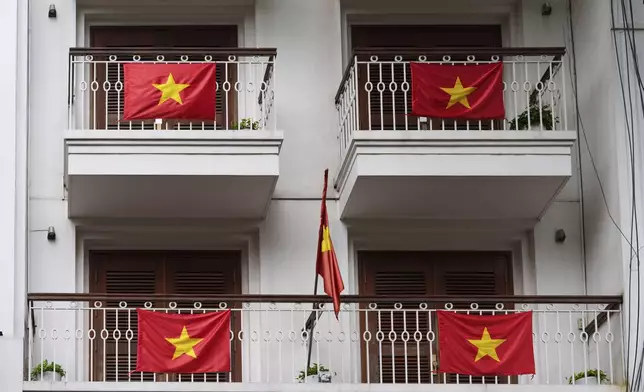 Vietnamese national flags decorate a building in the old quarter of Hanoi, Vietnam, Sunday, Aug. 31, 2025. (AP Photo/Vincent Thian)