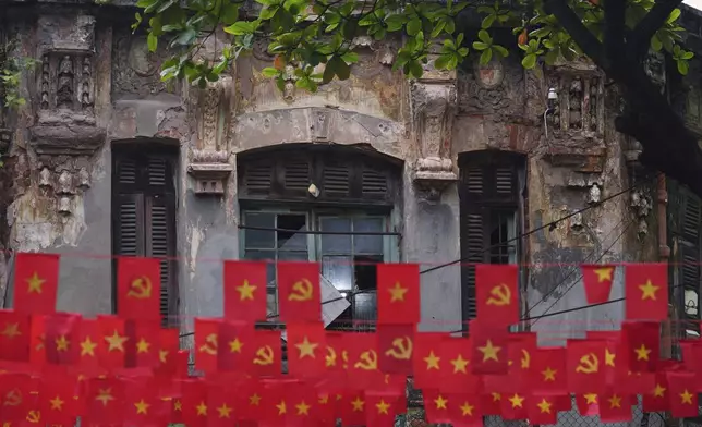Vietnamese and communist flags fly outside a house in the old quarter of Hanoi, Vietnam, Sunday, Aug. 31, 2025. (AP Photo/Vincent Thian)