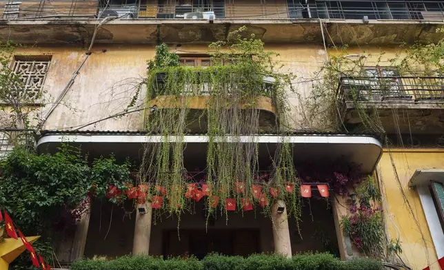 Vietnamese and communist flags hang on aa balcony in the old quarter of Hanoi, Vietnam, Monday, Sept. 1, 2025. (AP Photo/Vincent Thian)