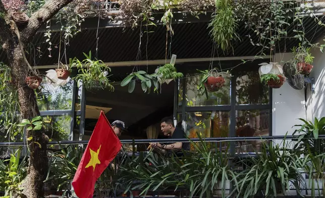 A Vietnamese national flag flies from a balcony in the old quarter of Hanoi, Vietnam, Sunday, Aug. 31, 2025. (AP Photo/Vincent Thian)