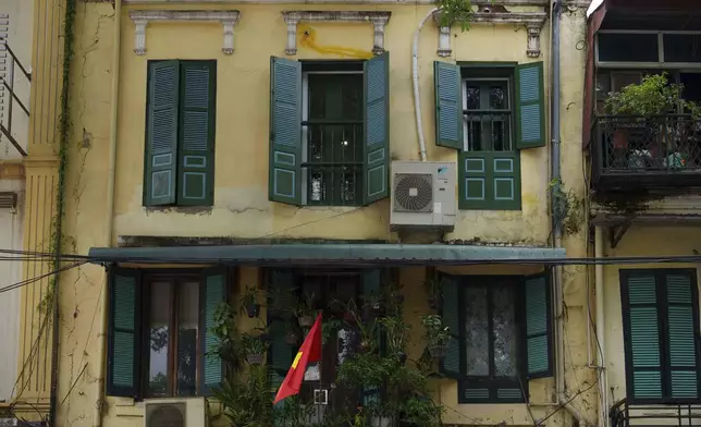A Vietnamese national flag flies outside a home in the old quarter of Hanoi, Vietnam, Sunday, Aug. 31, 2025. (AP Photo/Vincent Thian)