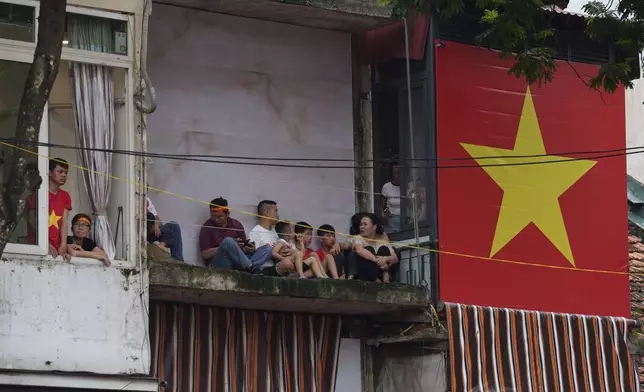 A giant Vietnamese national flag is displayed outside a balcony in the old quarter of Hanoi, Vietnam, Saturday, Aug. 30, 2025. (AP Photo/Vincent Thian)