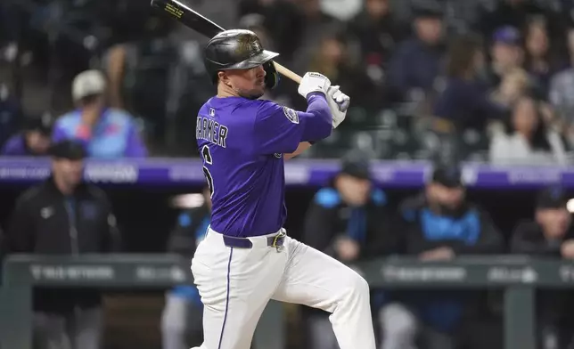 Colorado Rockies' Kyle Farmer follows the flight of his RBI single off Miami Marlins starting pitcher Ryan Weathers in the second inning of a baseball game Wednesday, Sept. 17, 2025, in Denver. (AP Photo/David Zalubowski)
