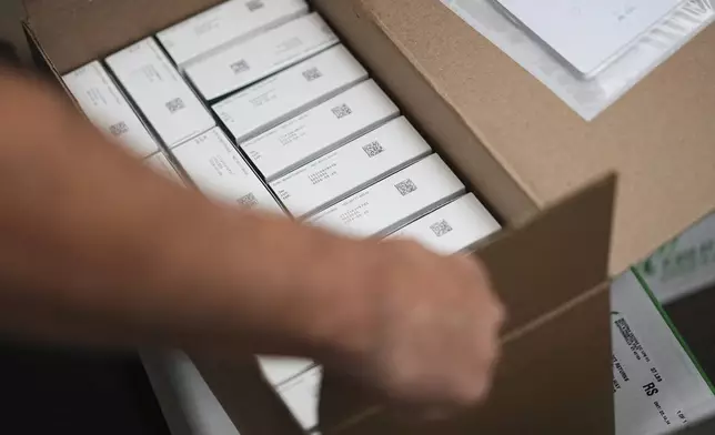 Co-owner Marc Ost at Eric's Rx Shoppe unpacks a shipment of COVID-19 vaccines in Horsham, Pa., Tuesday, Sept. 2, 2025. (AP Photo/Matt Rourke)